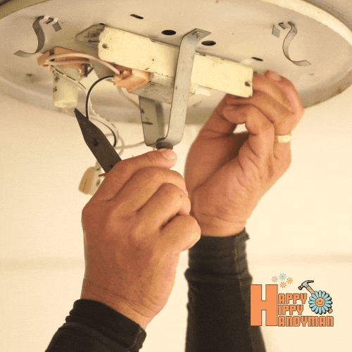 Installing a light fixture and tightening wires for correct electrical setup.