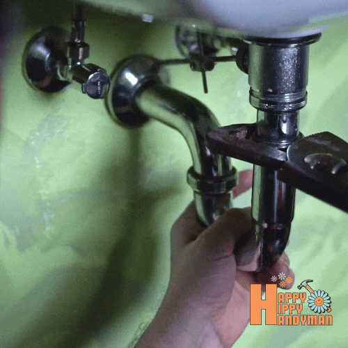 Close-up of a wrench positioned under a sink, essential for plumbing repair and leak prevention.