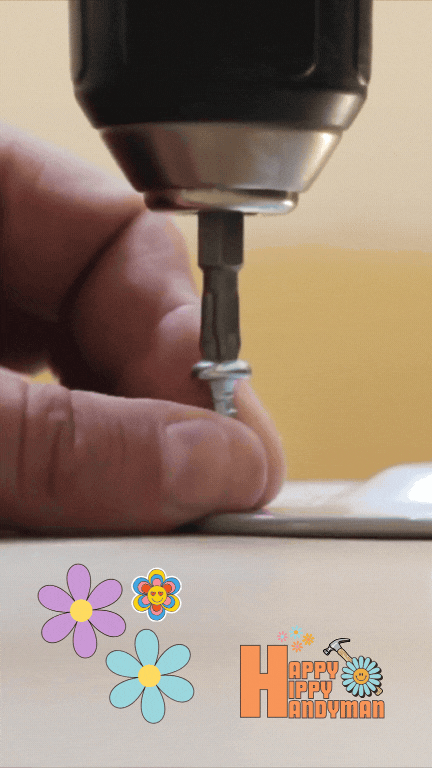 Driving a screw into a board, a common task in both toy assembly and furniture assembly projects.